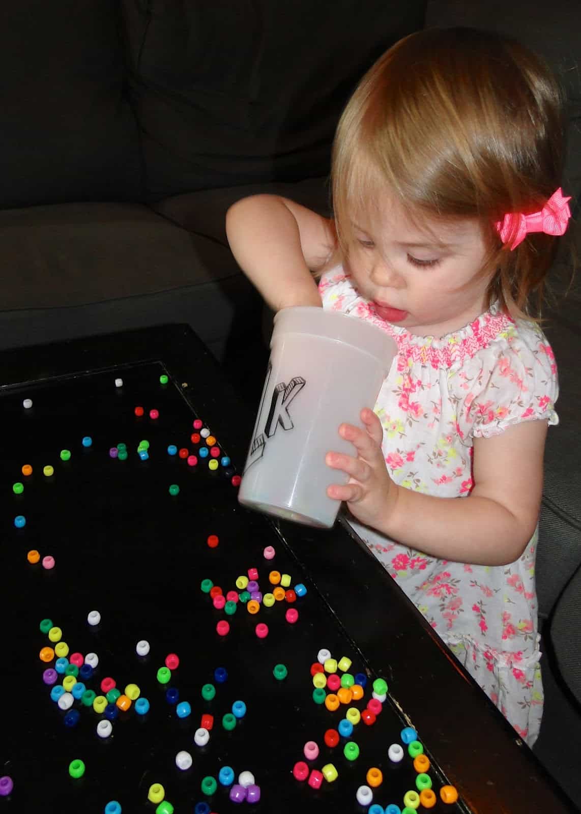 girl toddler playing with beads