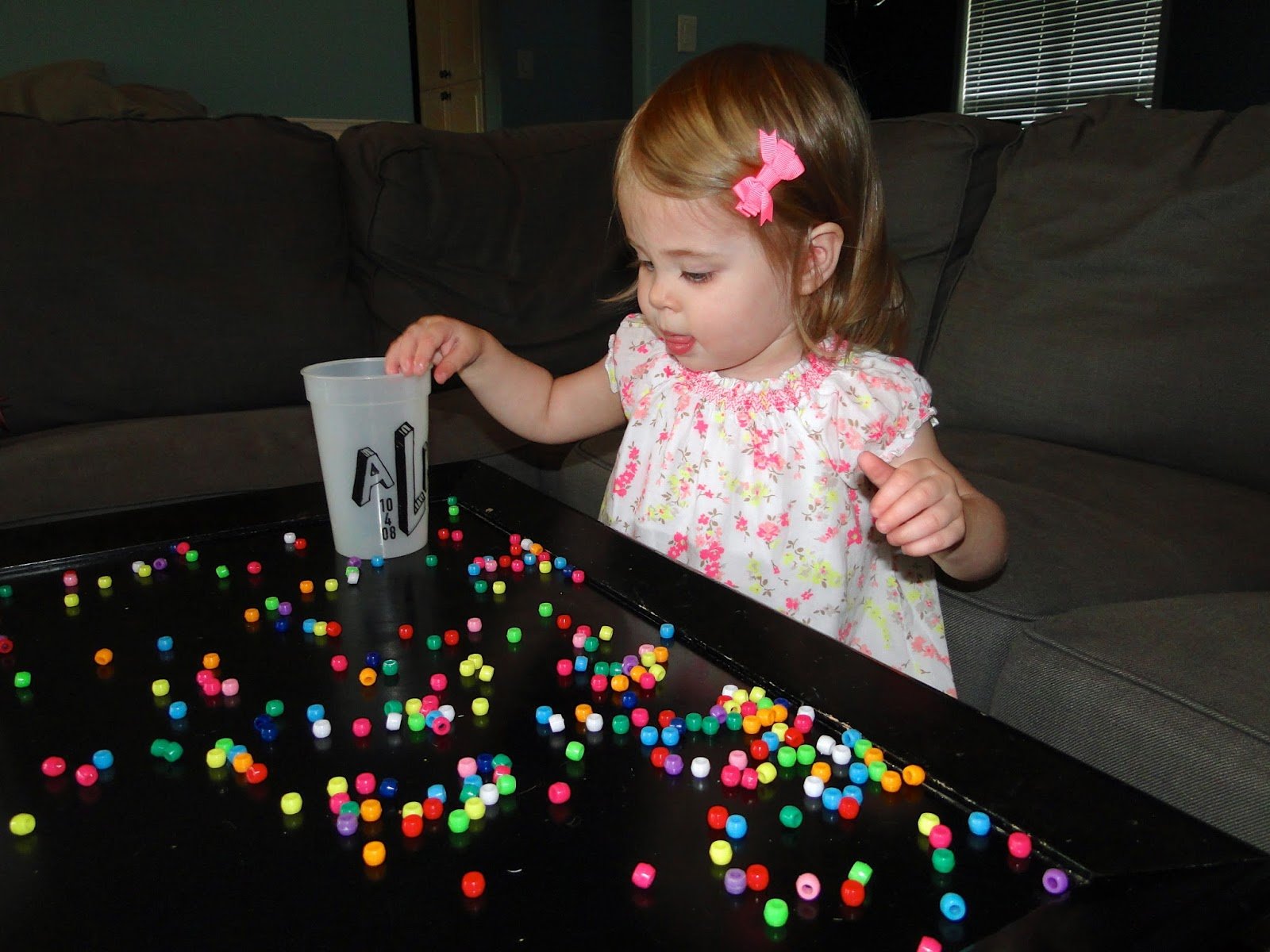 girl toddler playing with beads