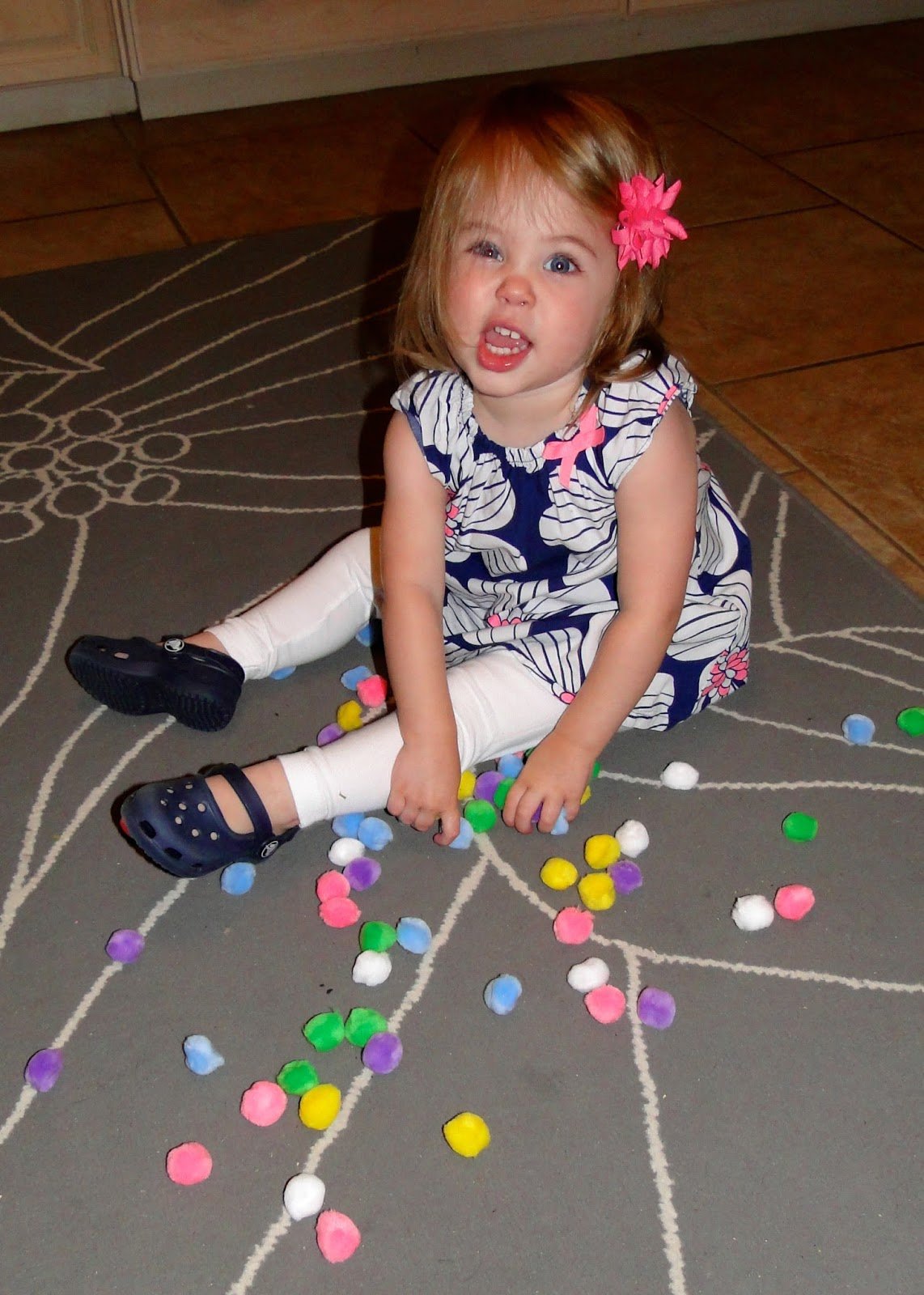 toddler girl playing with Pom Poms