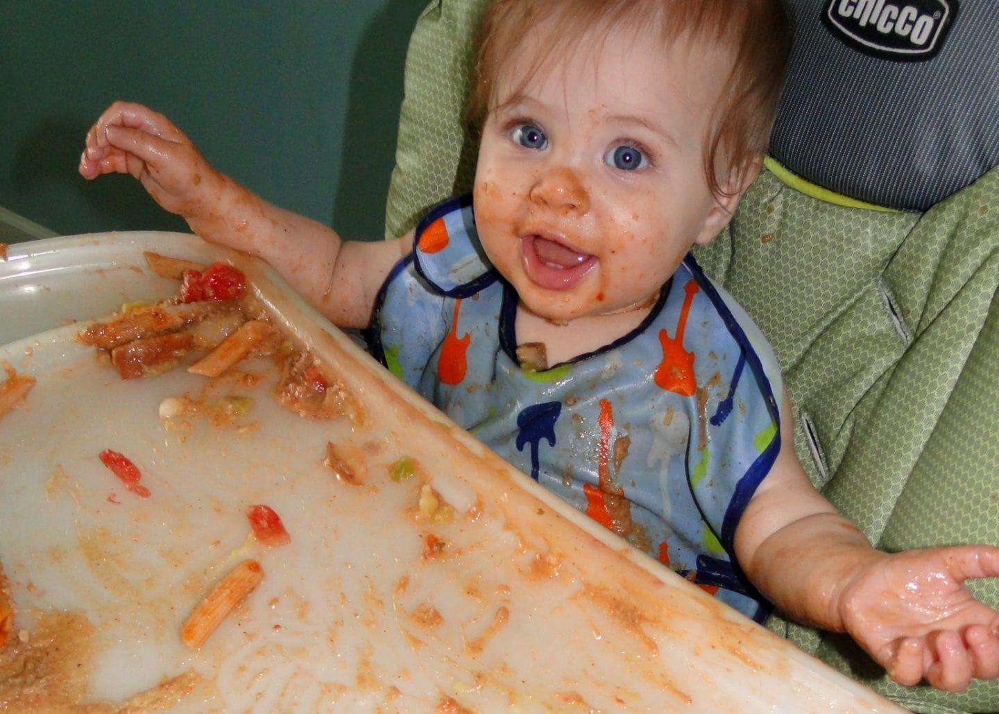 baby making mess in high chair on baby led weaning guide