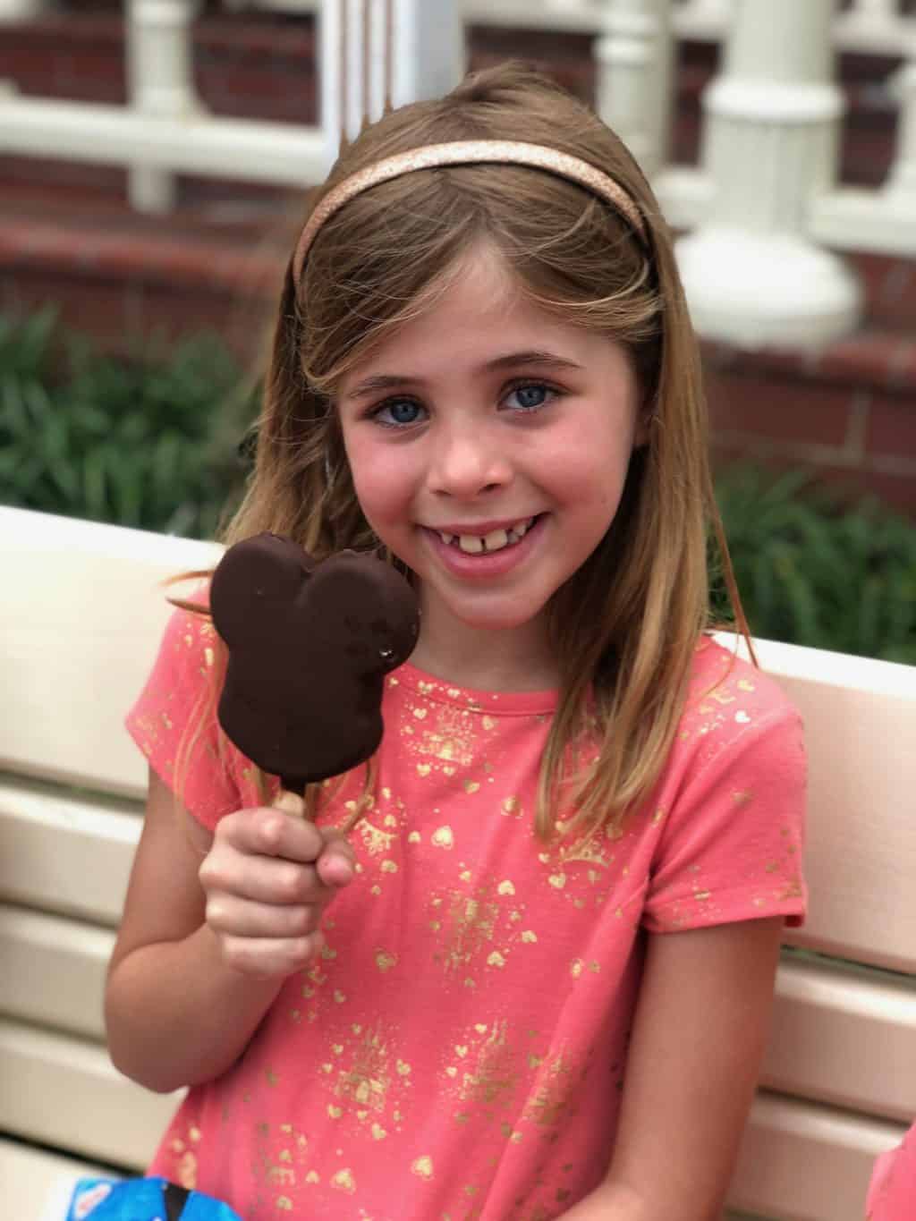 girl eating mickey bar ice cream