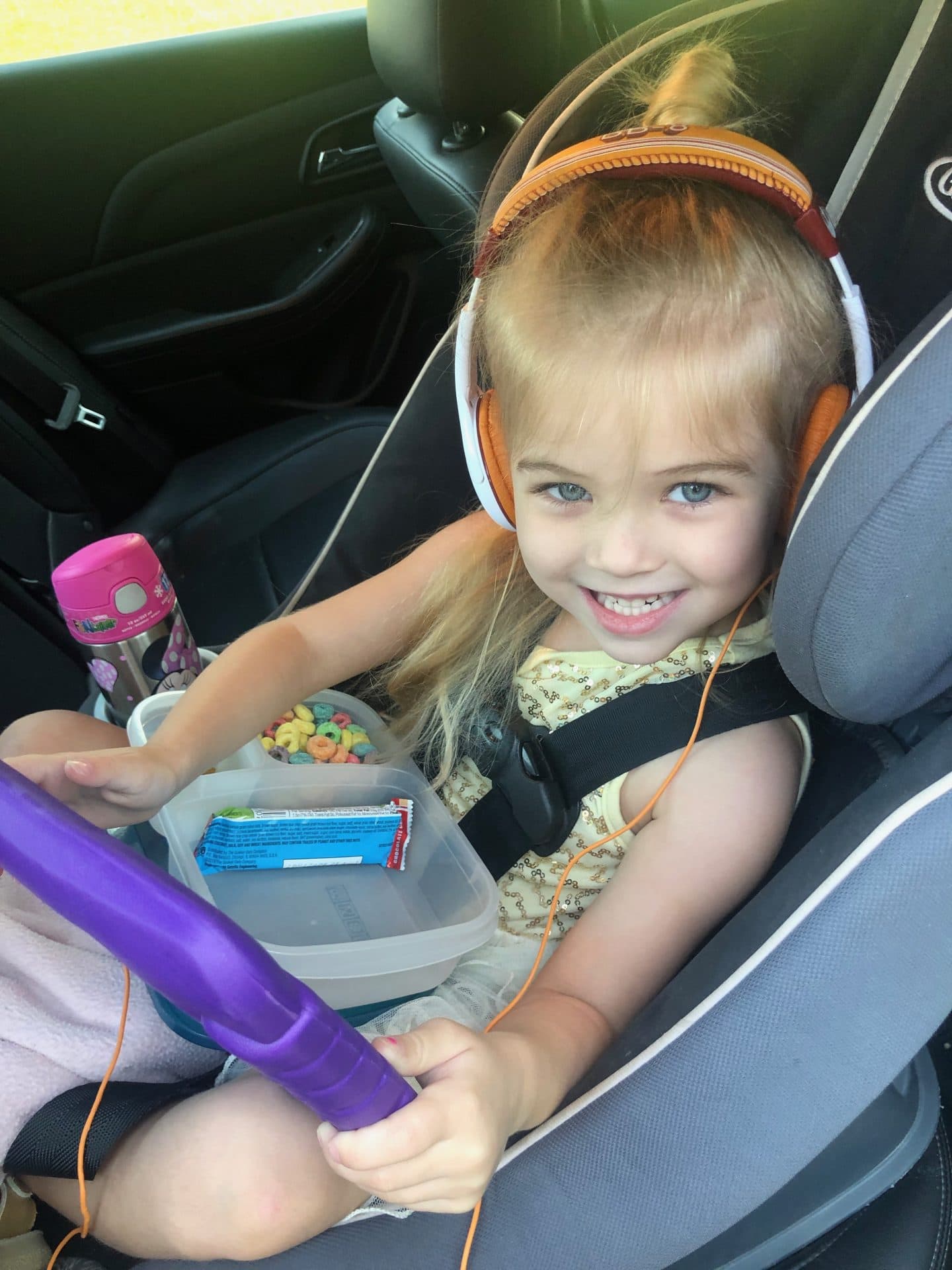 girl in car seat on road trip