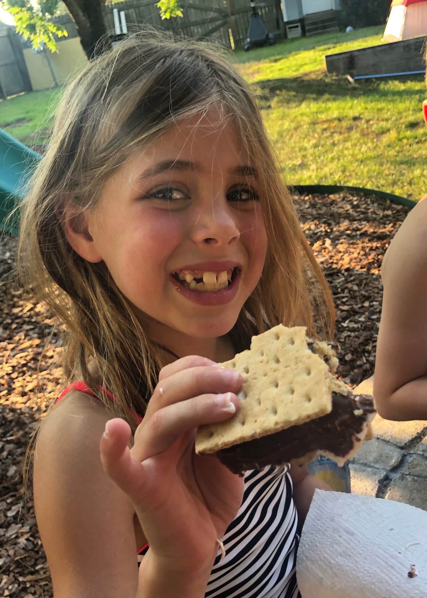 children camping and eating s'mores