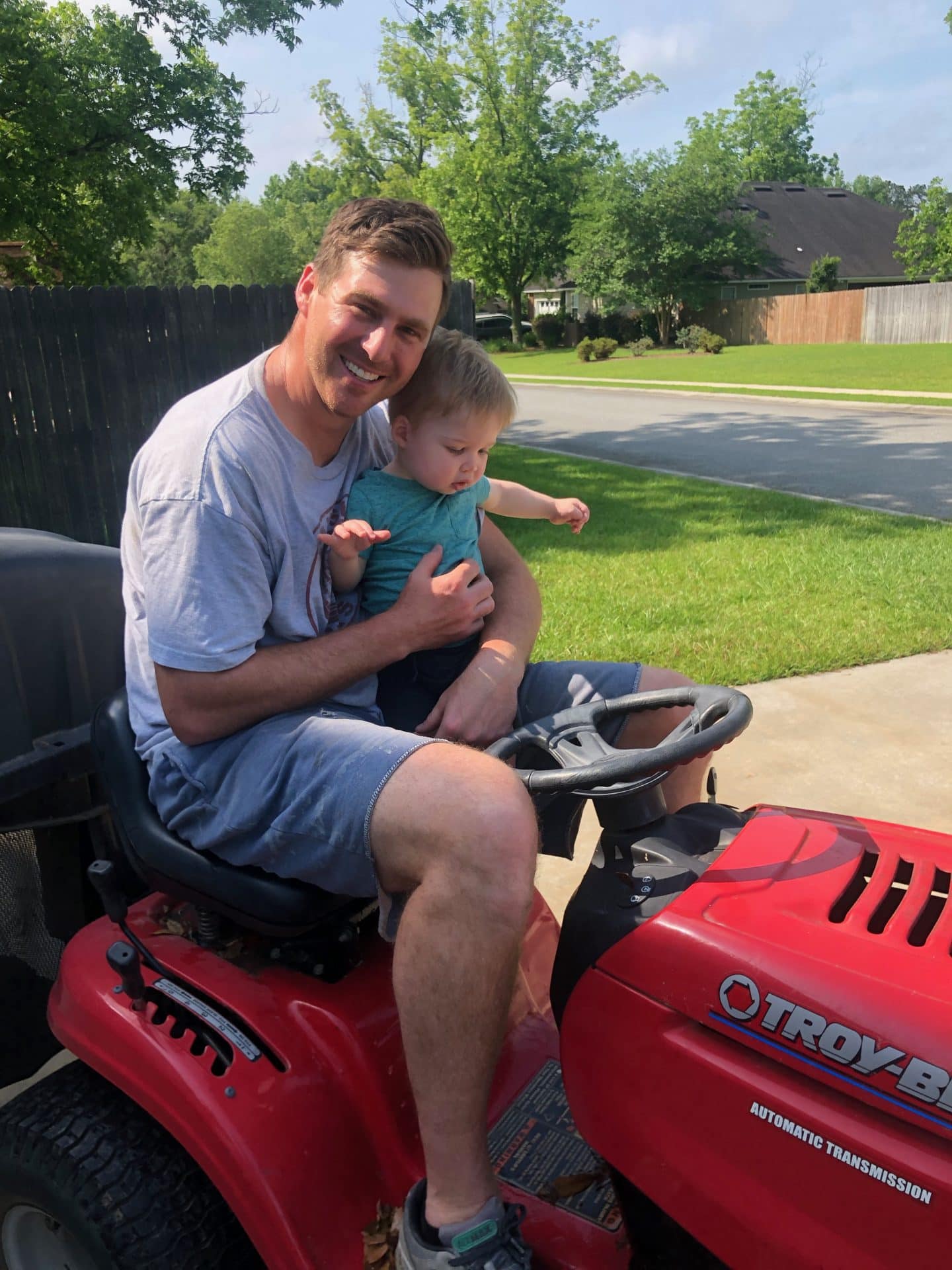 toddler helping mow grass