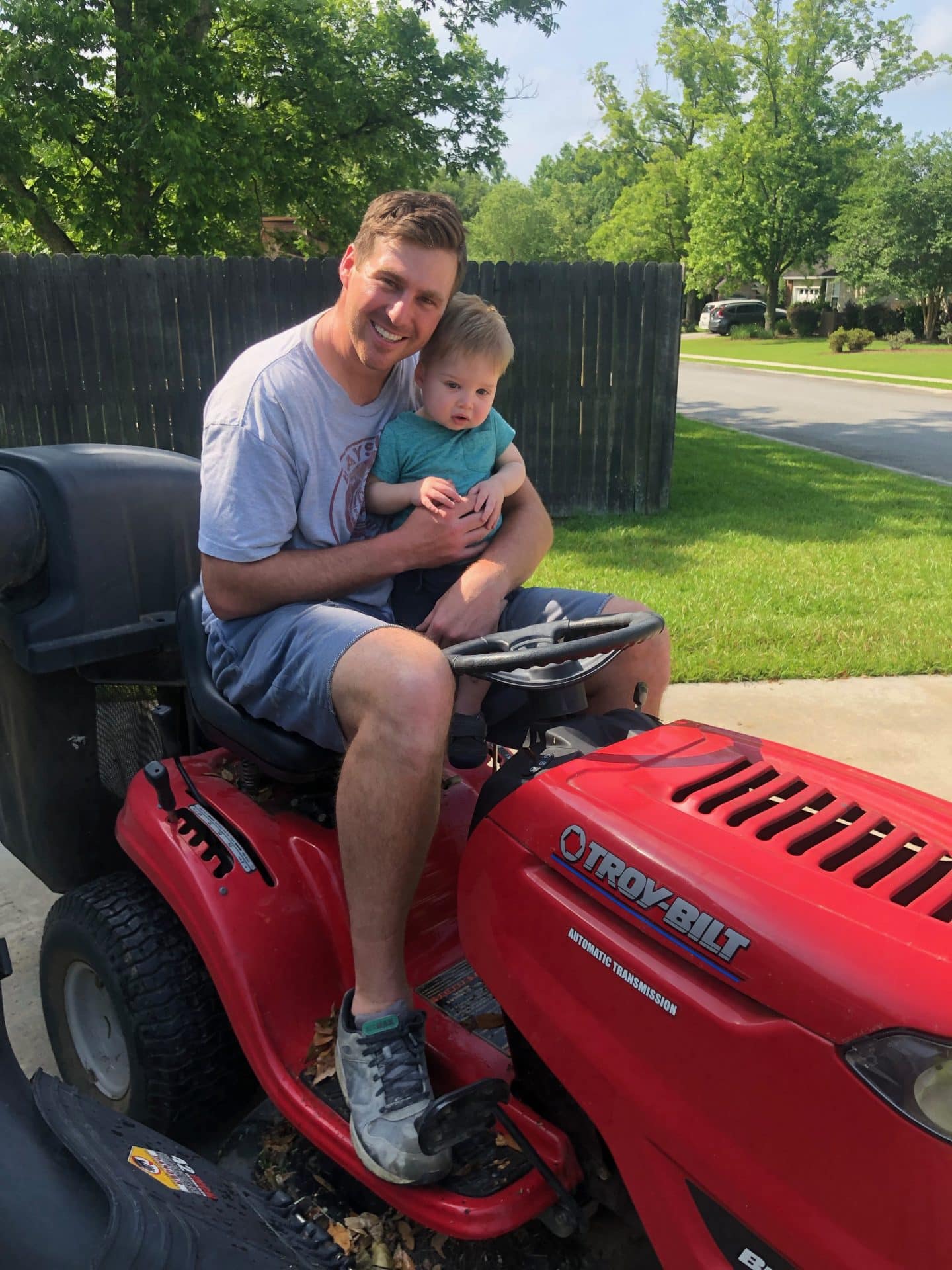 toddler helping mow grass