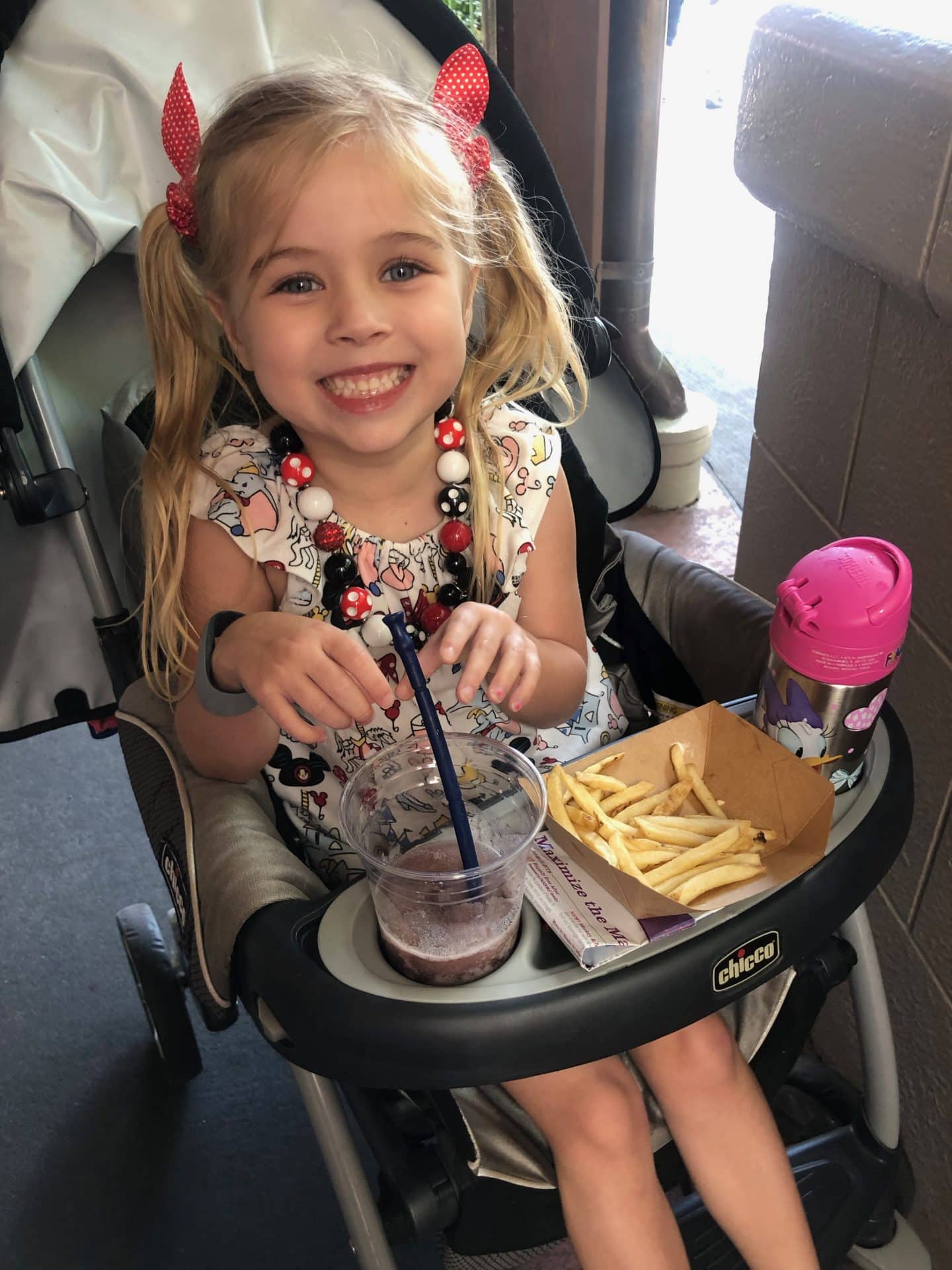 girl eating food in stroller at disney