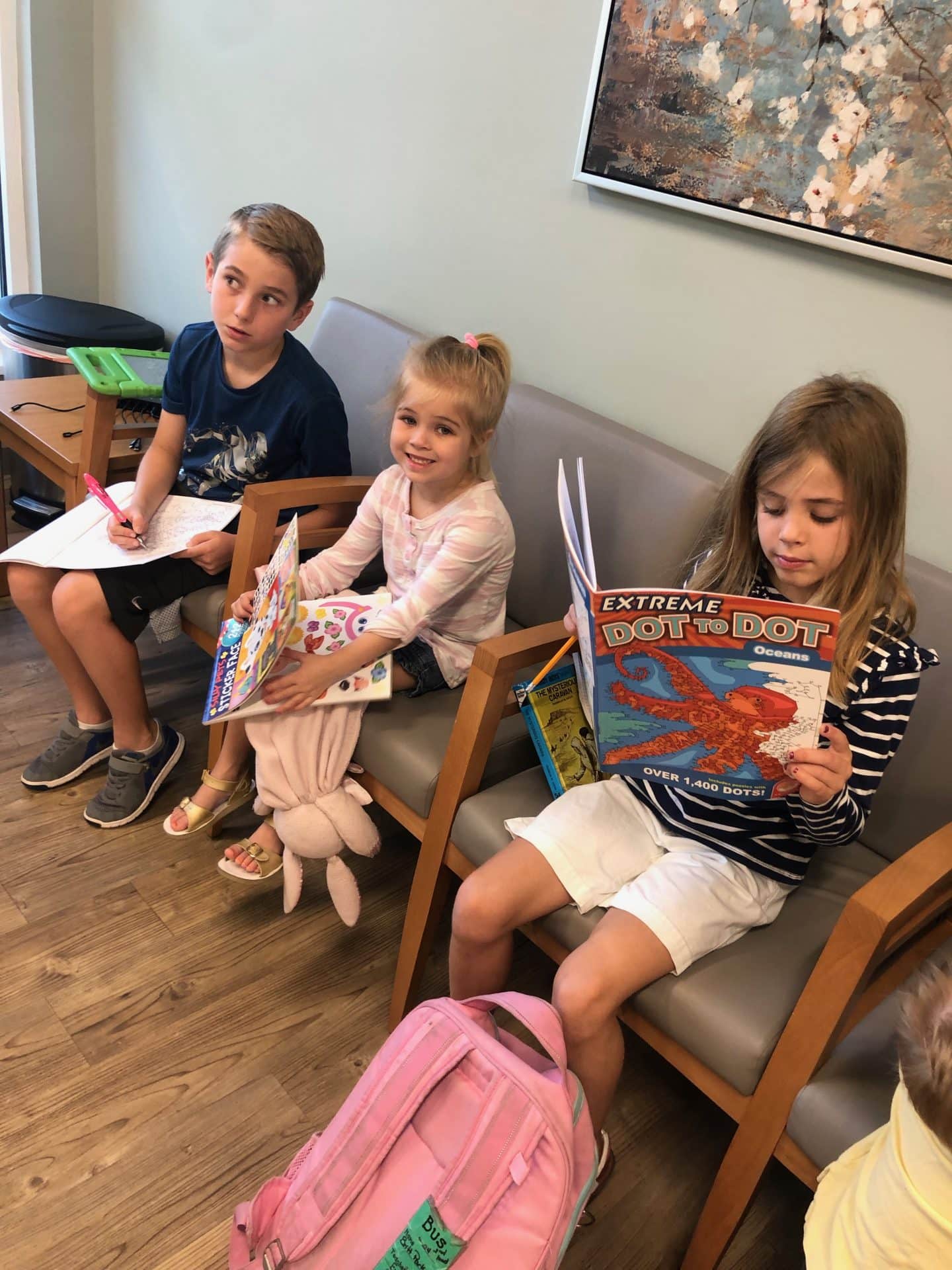 three kids sitting in dr waiting office