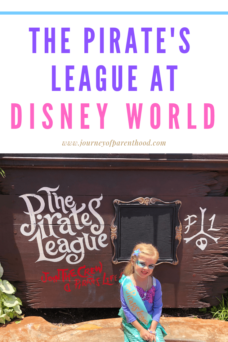 little girl makeover to a mermaid at Disney World sitting in front of the pirates league sign at magic kingdom