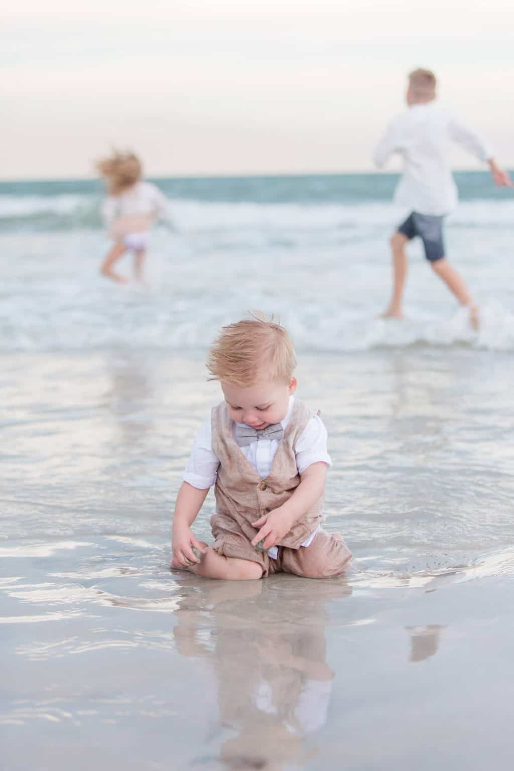 little boy playing in ocean water at the beach