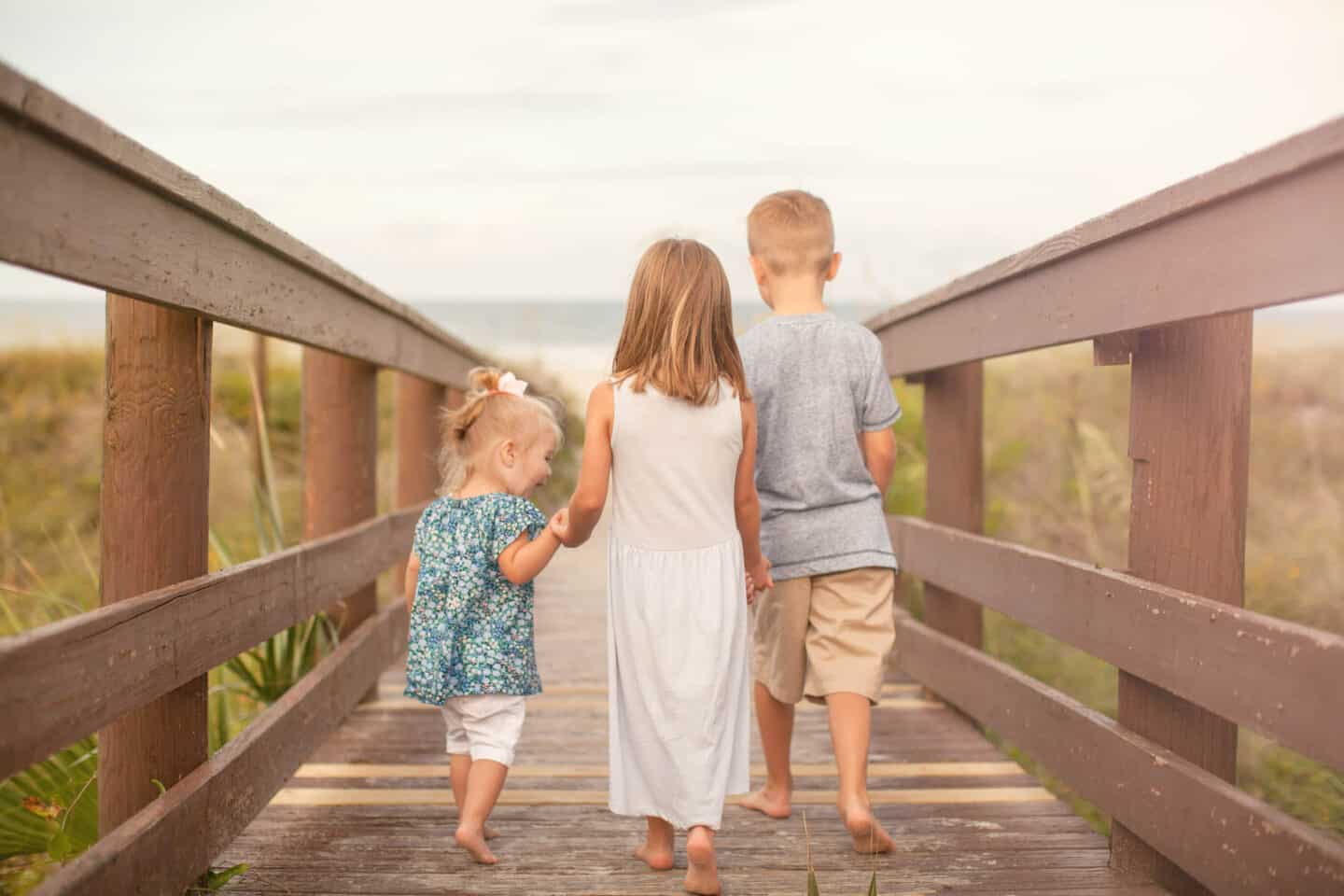 kids walking down boardwalk at the beach